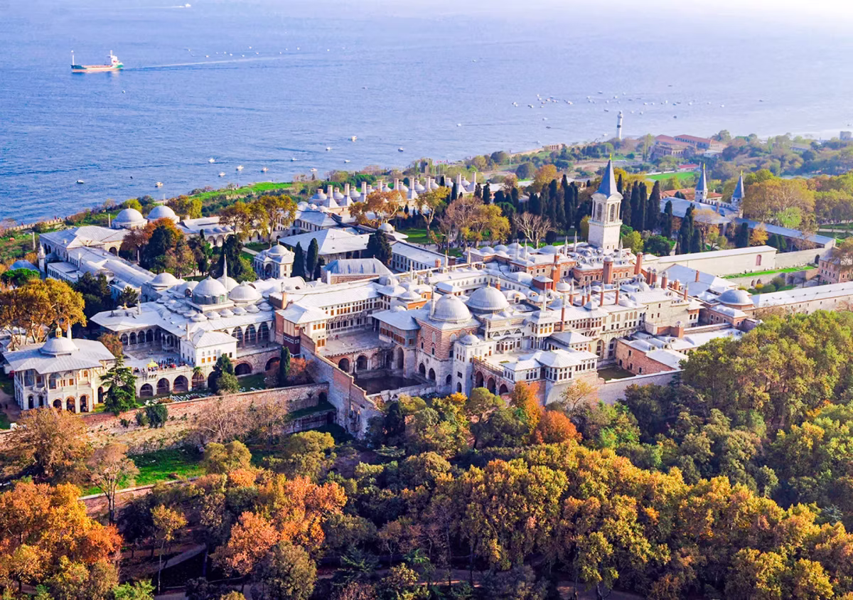 Aerial view of Topkapi Palace complex with domes and courtyards beside the Bosphorus in Istanbul.