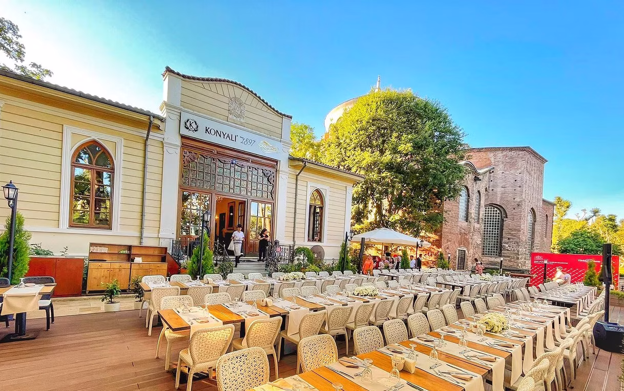 Outdoor dining area with set tables in front of Konyali 1897 restaurant in Istanbul.